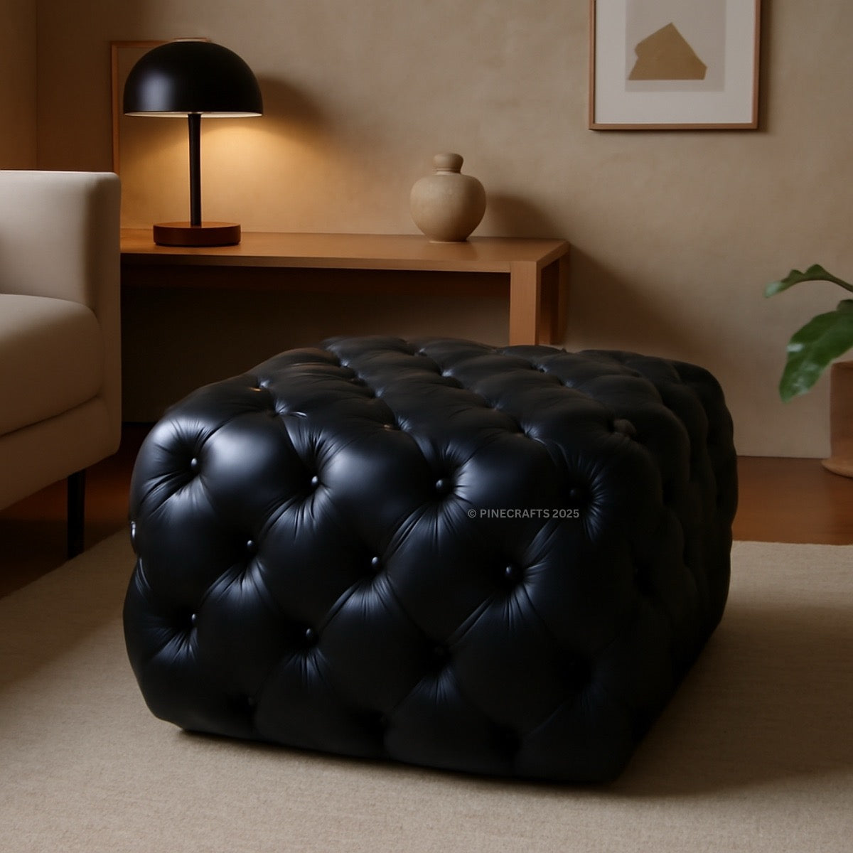 Black tufted ottoman in a living room setting with a lamp and decor items.